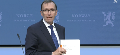 Espen Barth Eide holder en kopi av NOU-en fra genteknologiutvalget på en pressekonferanse. - Foto: Skjermdump/Regjeringen.no